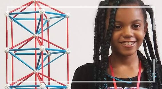 A child holding up a mechanism that she built