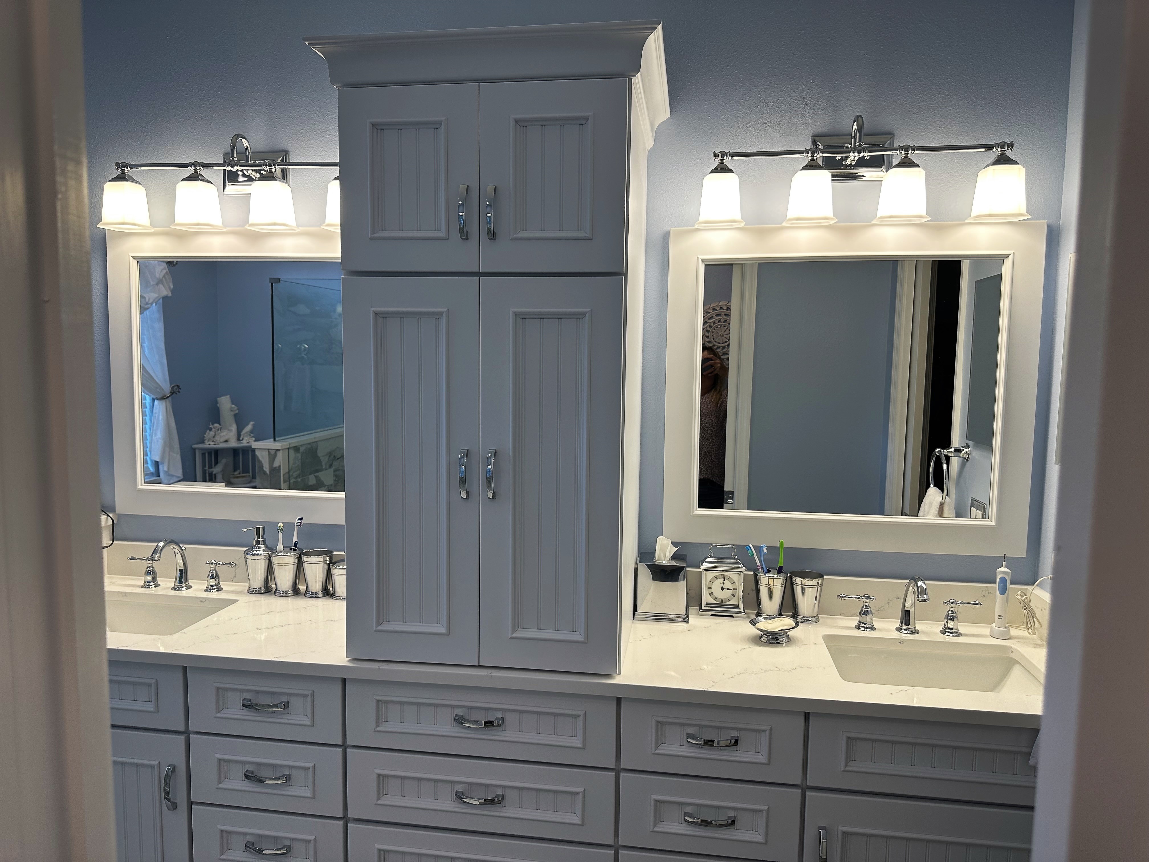 Perfectly framed mirrors with matching lighting featuring dual sinks and drawers for storage make this an ideal bathroom vanity for two.