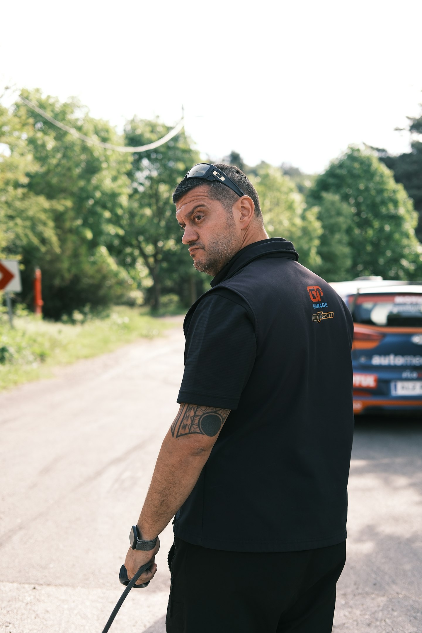 a man holding a stick on the side of a road