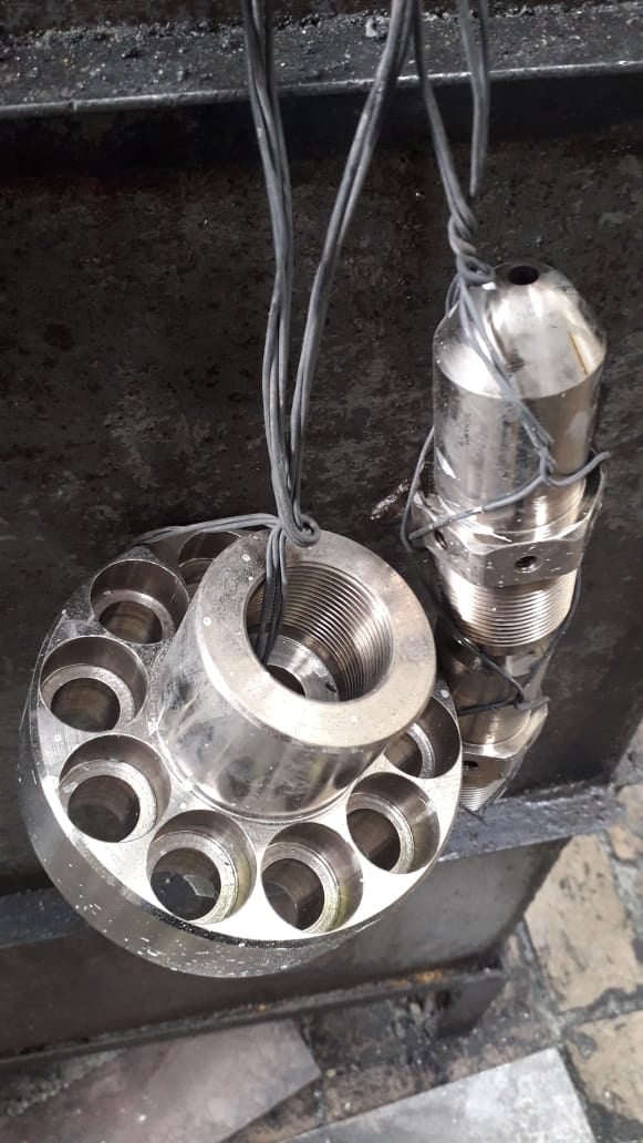 Conjunto de piezas mecánicas metálicas colgadas con cables en un entorno industrial.