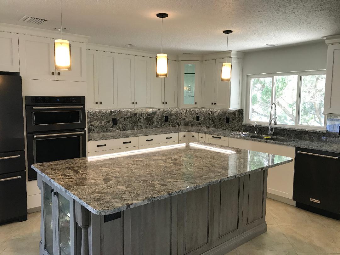 Ageless kitchen with huge custom Island featuring three drop down pendant lights.