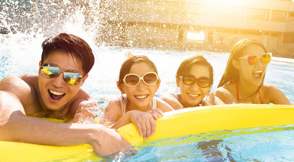 Happy Family Playing In Swimming Pool