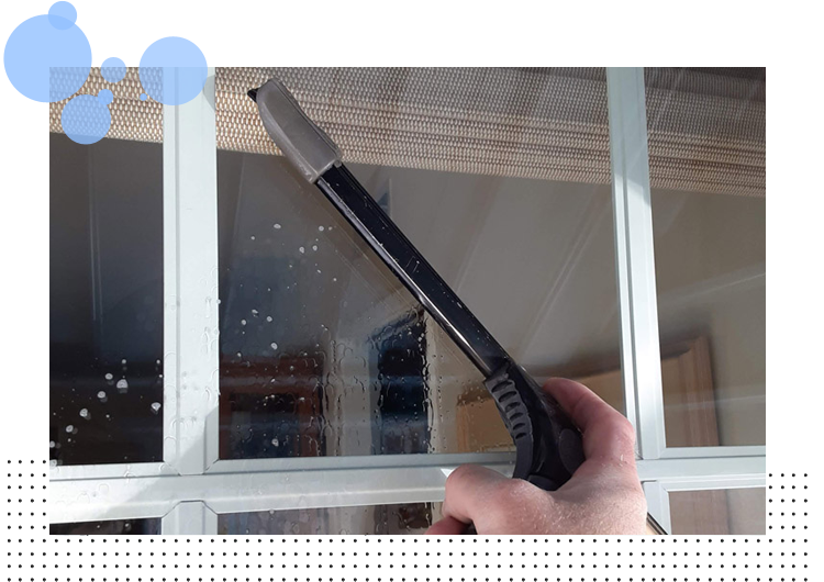 Gloved hand cleaning window rag and spray