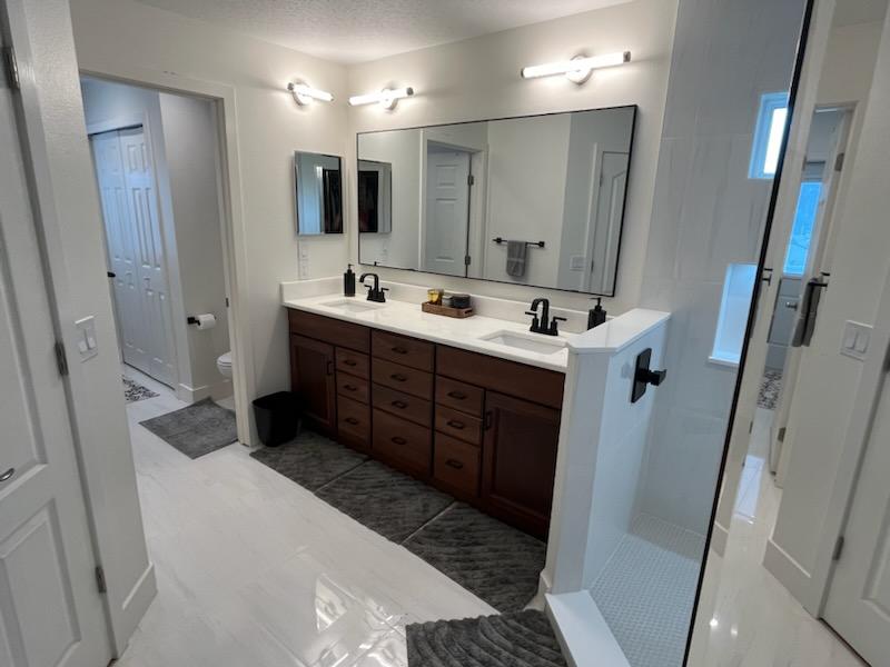 This beautiful bathroom showcases rich dark cabinetry paired with a modern clean aesthetic.