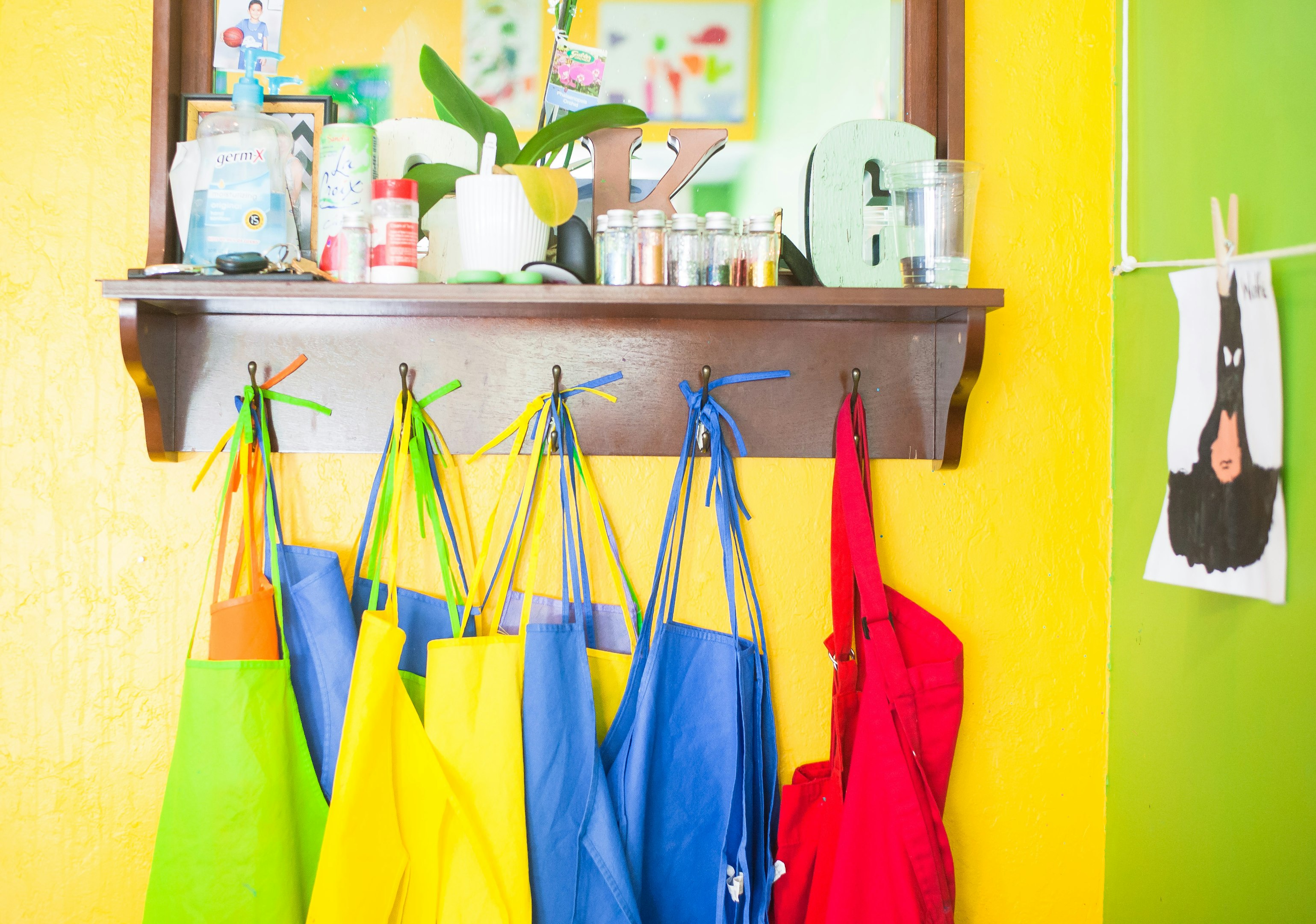lote de bolsos de colores variados colgando en un estante de madera marrón