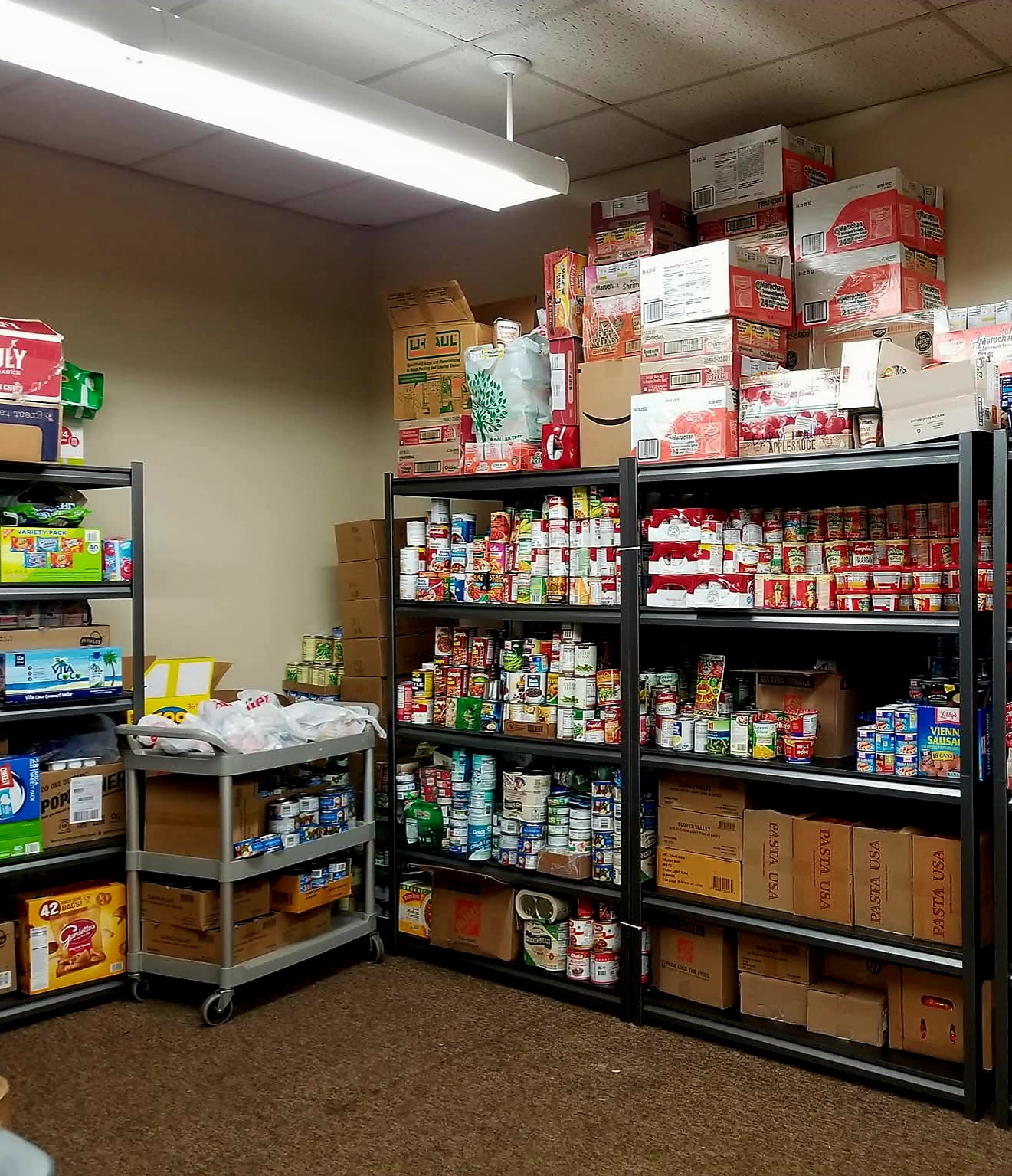 Stocked food pantry with shelves of canned goods, packaged foods, and boxes; organized storage area. Stocked food pantry with shelves of canned goods, packaged foods, and boxes; organized storage area.