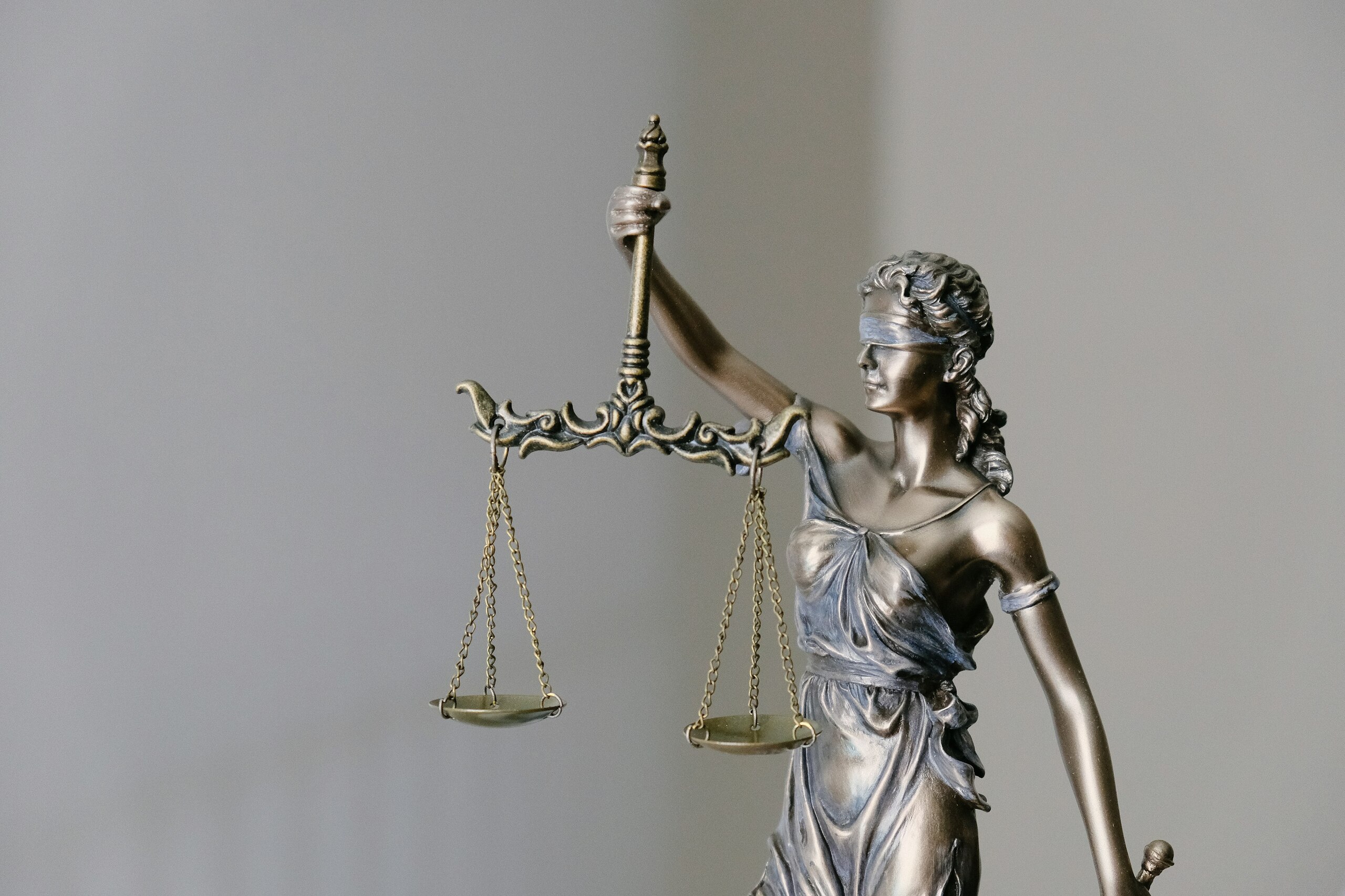 Estatua de la justicia con balanza en mano, símbolo de imparcialidad y equidad.
