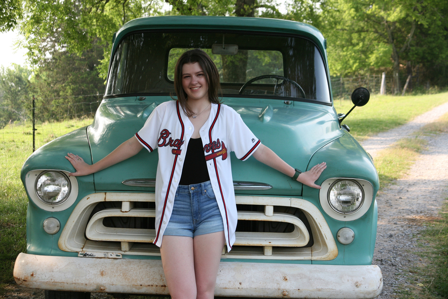 Portrait of a teenage girl in front of a car