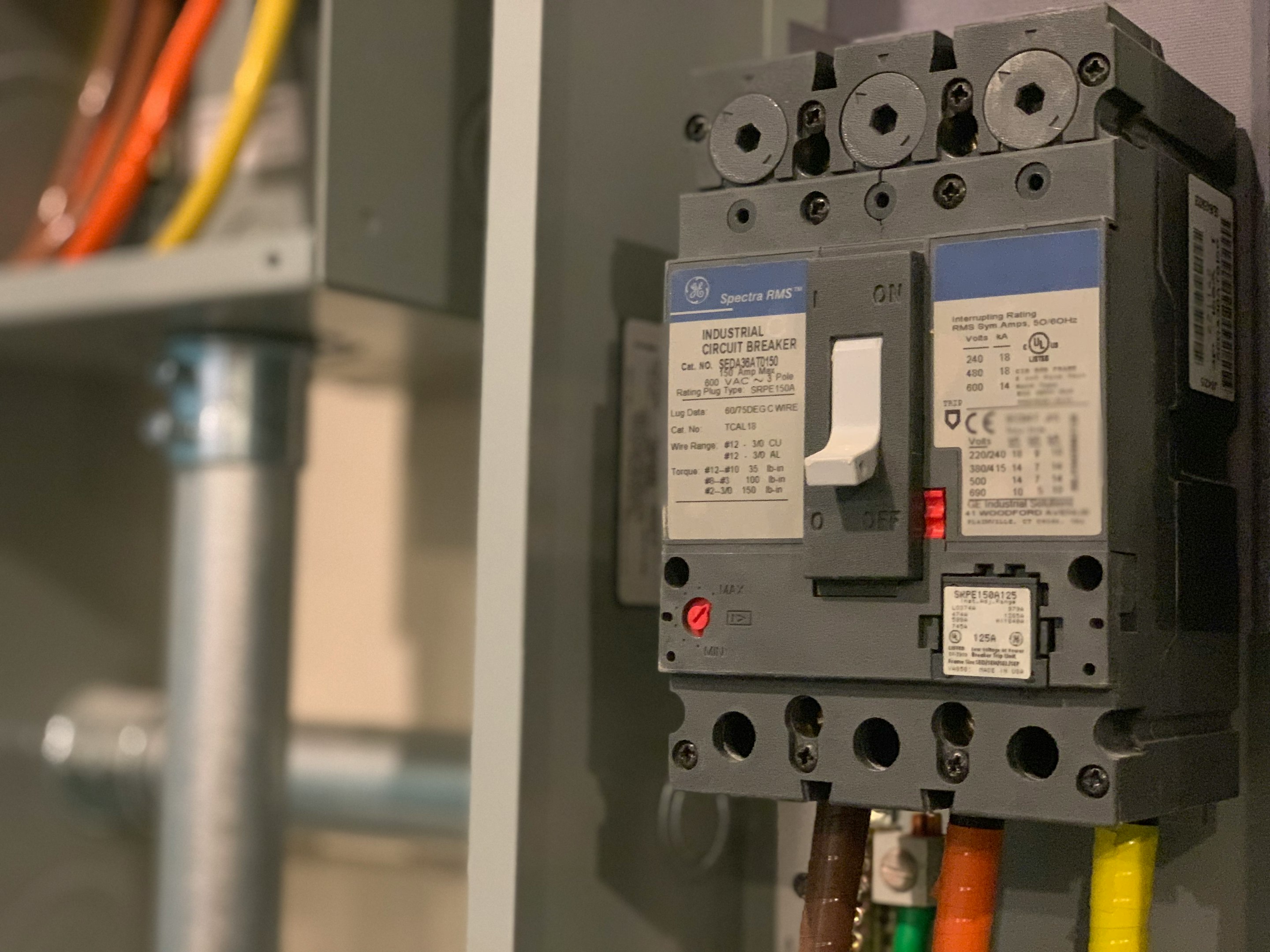 Technician adjusting electrical panel in industrial setting