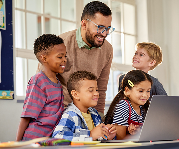 Children studying with teacher and computer