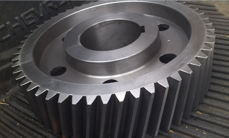 Engranaje de metal grande sobre superficie acanalada.