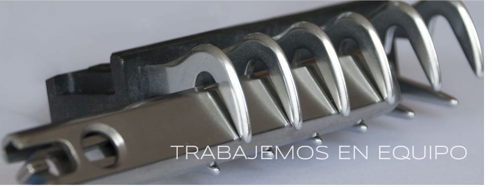 Imagen de un objeto metálico con ganchos en espiral y texto 'TRABAJEMOS EN EQUIPO' en primer plano.