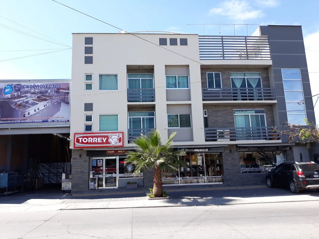 Pasillo de supermercado con refrigeradores llenos de productos envasados y luces brillantes.