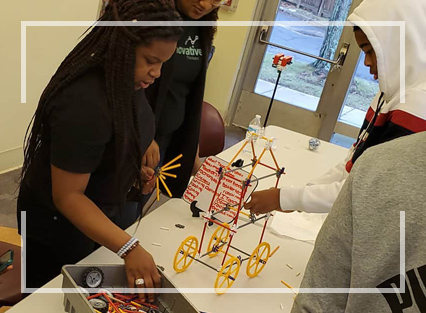 Five students building a cart with wheels
