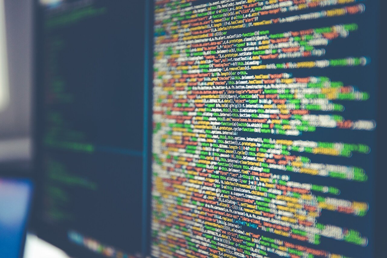 Pantalla de computadora mostrando líneas de código en varios colores, representando programación y desarrollo de software.
