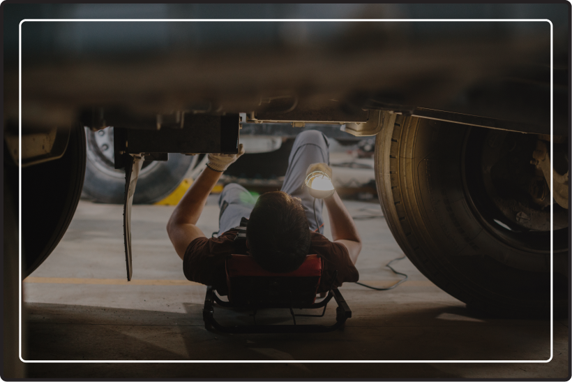A mechanic laying under a truck
