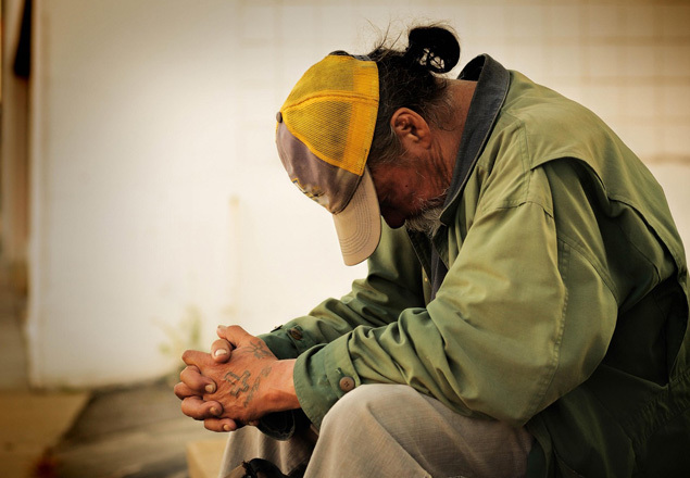 A man with his head bowed down and hand folded, praying A man with his head bowed down and hand folded, praying