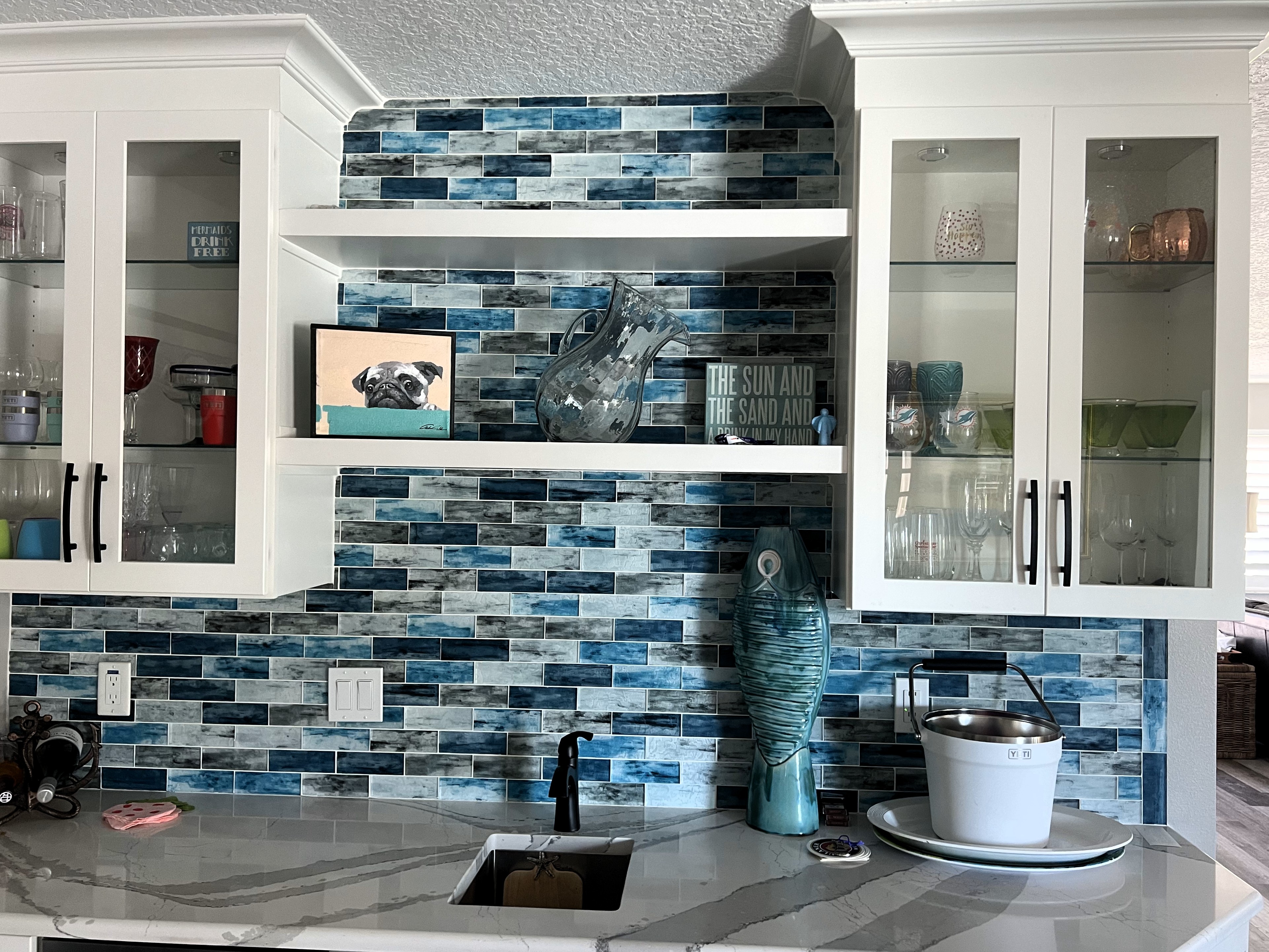 Wet bar area featuring a fun and unique multi-color backsplash with bar sink, white cabinetry, and Cambria countertop.