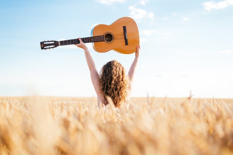 Woman with a Guitar in a Field