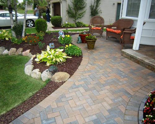 An artfully laid out patio highlighted by custom landscaping and rock wall