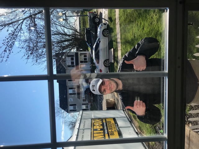 Sunlit dining room with large windows, wooden table set for dinner, and cozy seating area.
