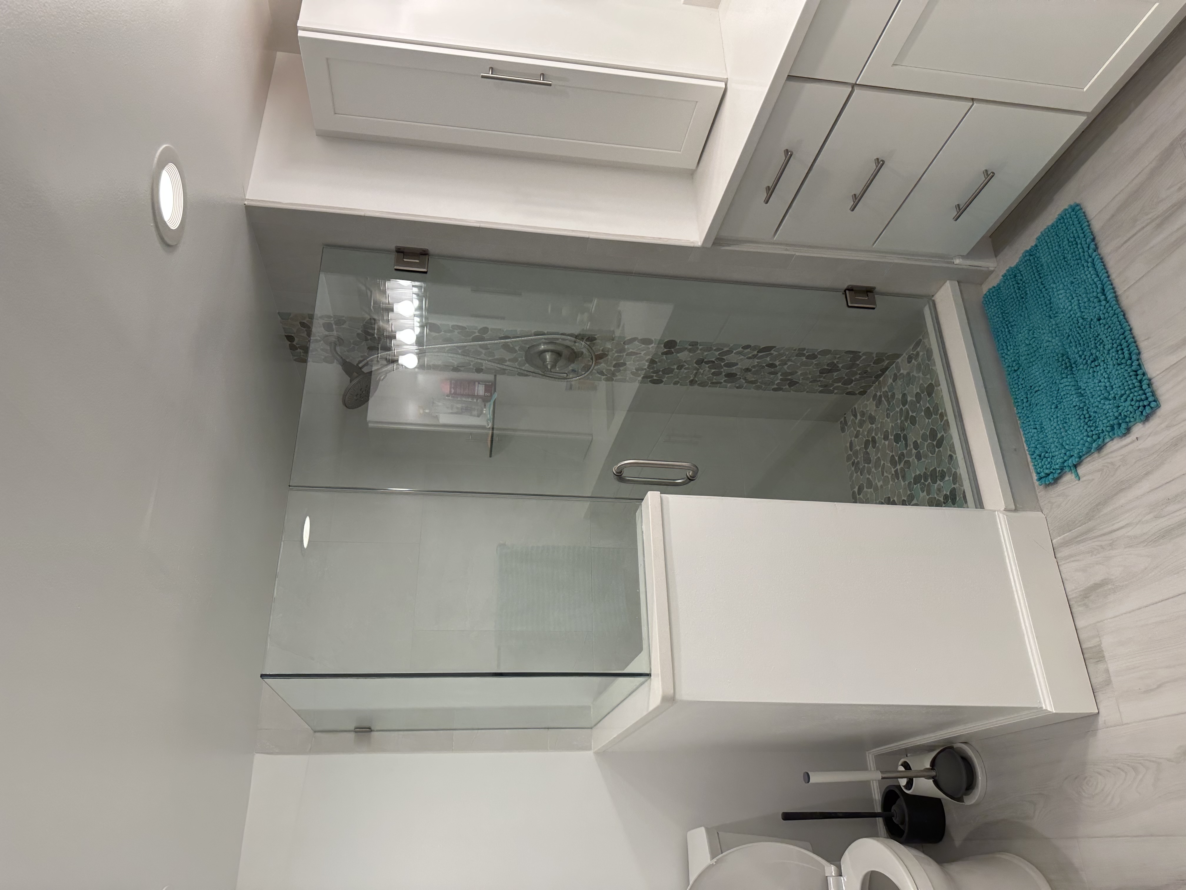 Walk-in shower featuring 12x24 wall tile with 3/8" heavy glass panels and door.