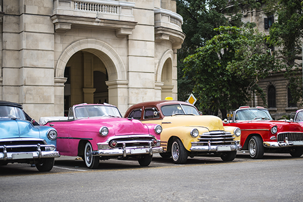 colorful classic cars in front of historic building on the streets of havana cuba