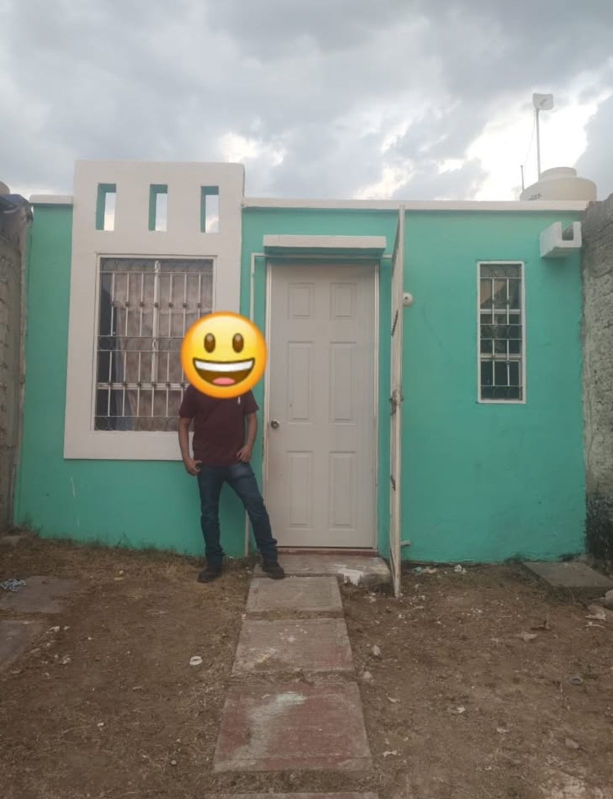 Sala de estar moderna con grandes ventanales, sofás blancos, mesa de centro redonda y vistas a la naturaleza exterior.