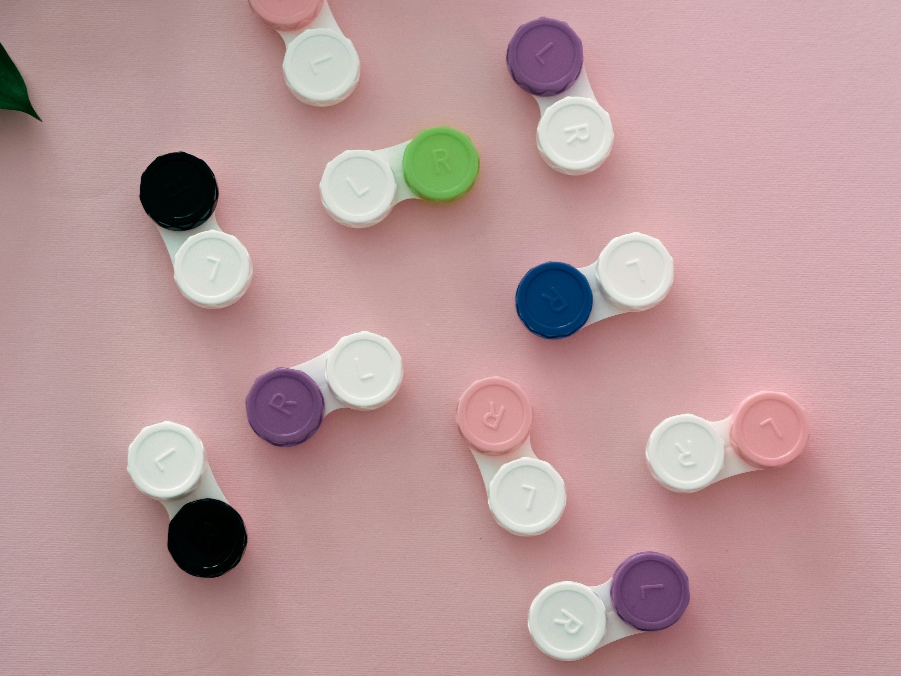un grupo de botones de diferentes colores en una superficie rosa