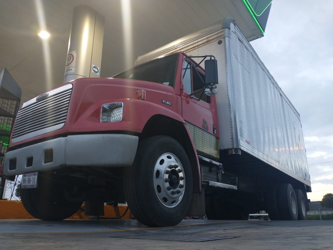 Camión de carga rojo estacionado en una estación de servicio. Camión de carga rojo estacionado en una estación de servicio.