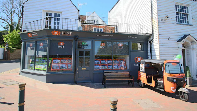man in black t-shirt and gray pants standing near white wall