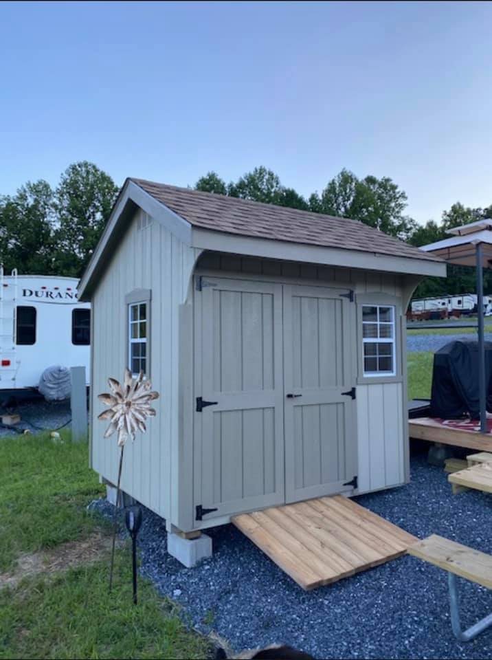 8 x 8 New England Deluxe Quaker              
                                                             Featuring almond colored wood siding, clay colored wooden trim, cedar colored 30 year architectural shingles with tarpaper underlayment, clay box trim.

Standard Features Includes: 50” doors, gable vents, 2-18”x27” slider windows with screens, box trim or shutters, pressure treated floor joists, your choice of color combinations, 30 year architectural shingles with tarpaper underlayment.
All my structures come standard with a 10 year warranty of materials and workmanship!!

New England Package Includes: 7/12 roof pitch, New England solid door with “L” door handles, doors and trim painted the same color, New England wooden corners.