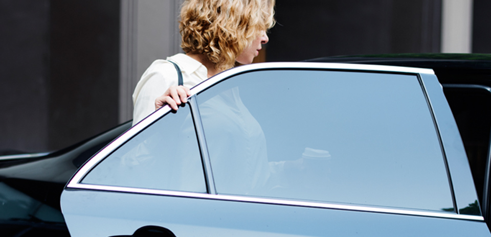 Woman entering vehicle, highlighting door-to-door transport convenience
