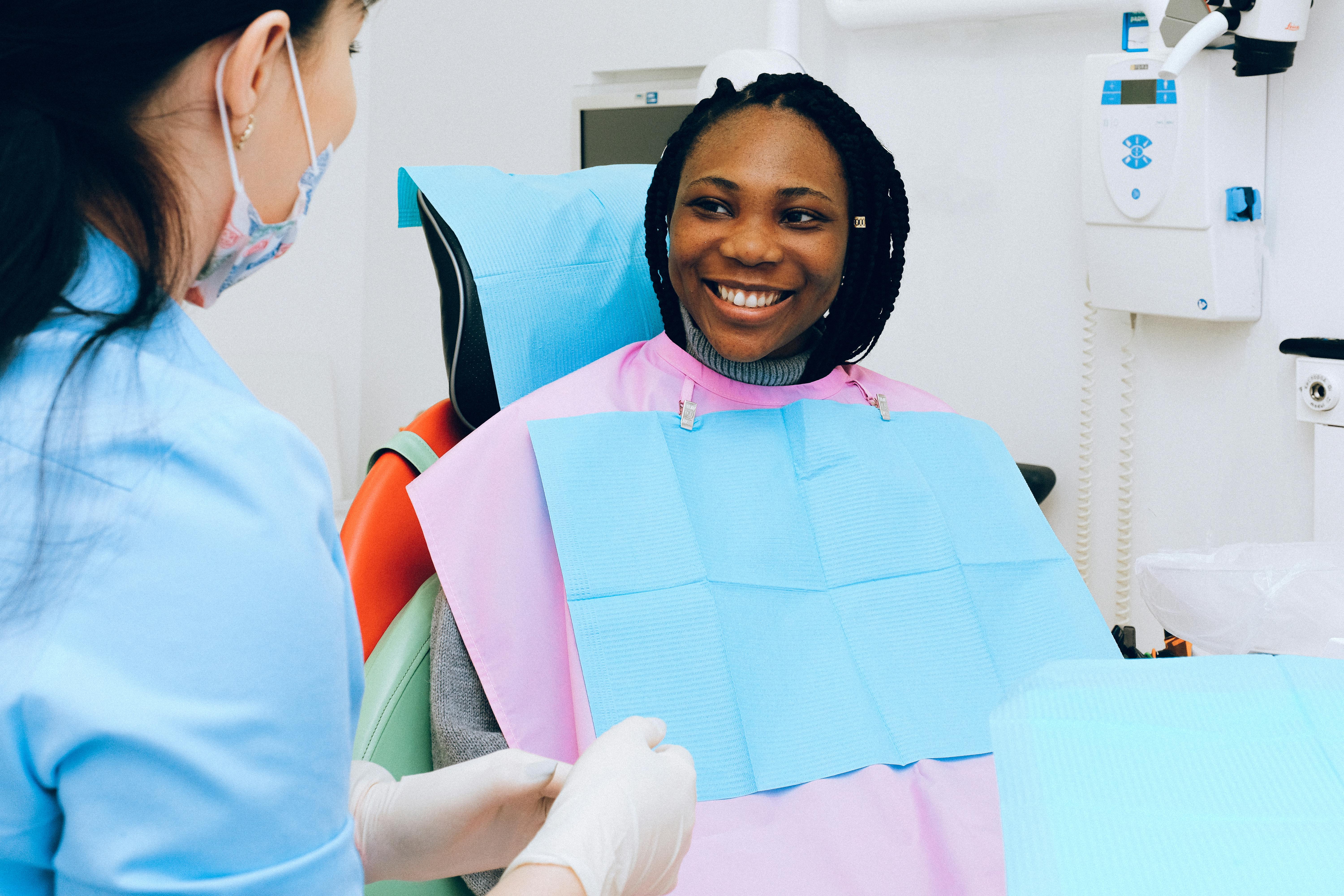 A woman looking at a dentist and smiling A woman looking at a dentist and smiling