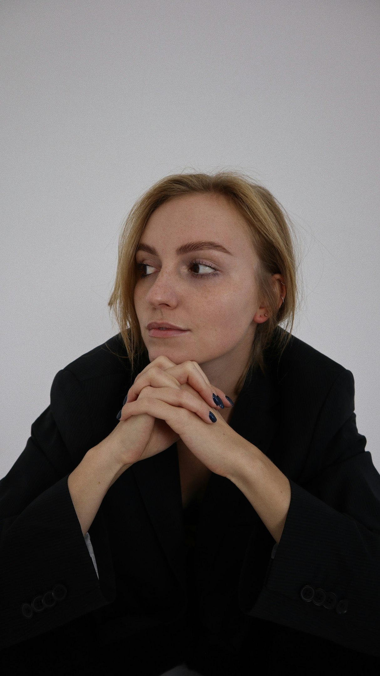 a woman in a black jacket is sitting down