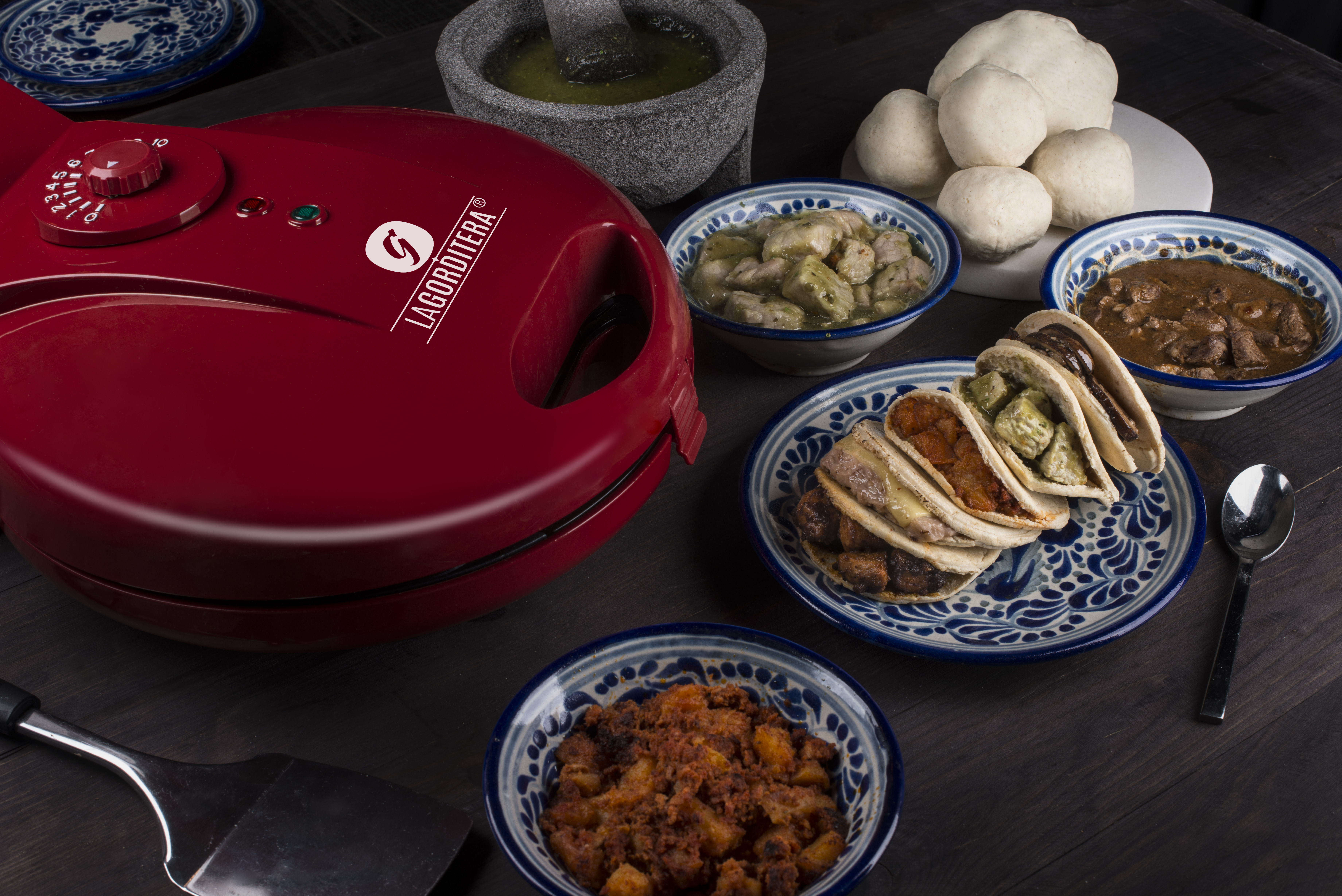 Máquina de hacer galletas roja con seis moldes redondos y galletas horneándose.