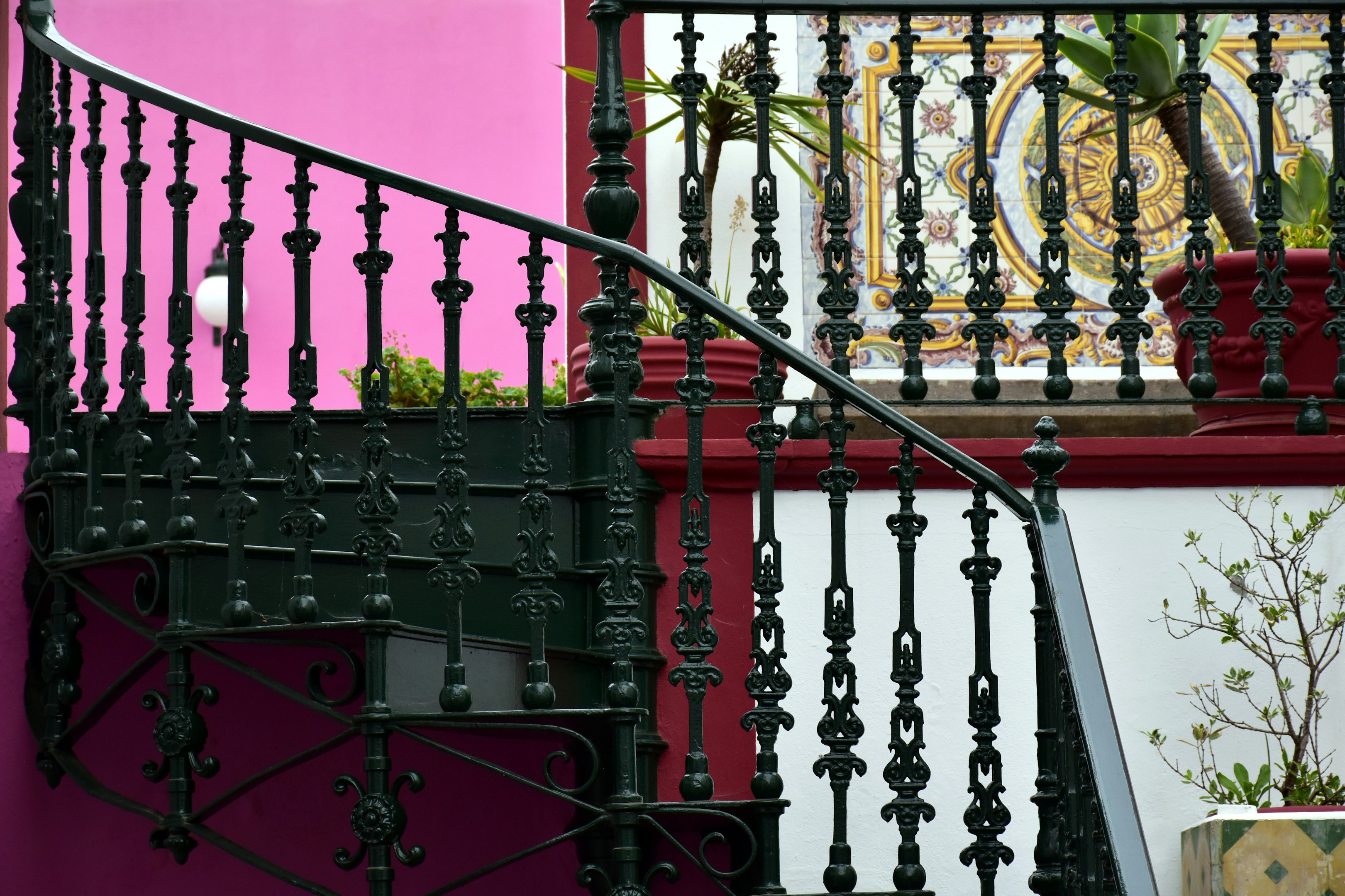 una escalera al lado de una pared rosa

