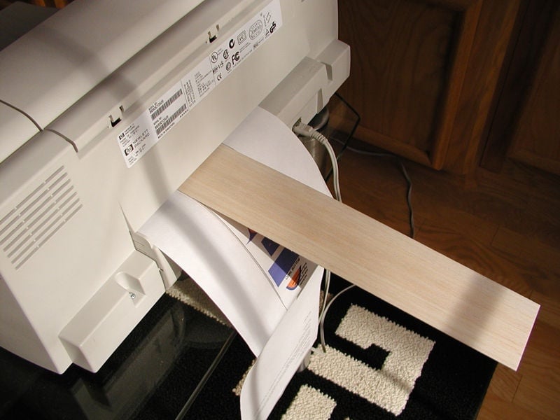 While holding the backing sheet and balsa strip, feed them into the printer until they register. You can make minor adjustments to the balsa sheet alignment after it is registered in the printer.