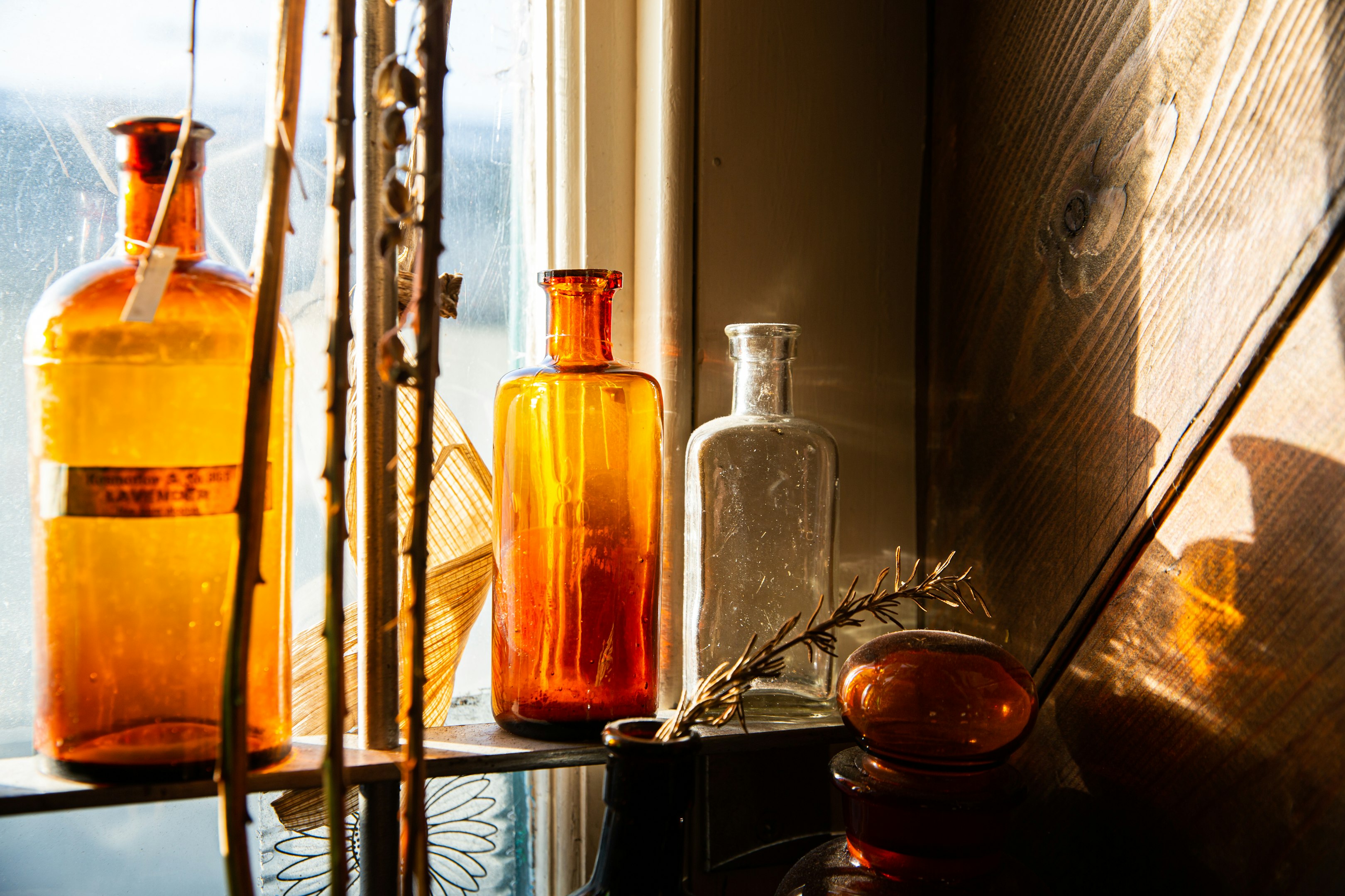 botellas de vidrio transparentes sobre mesa de madera negra