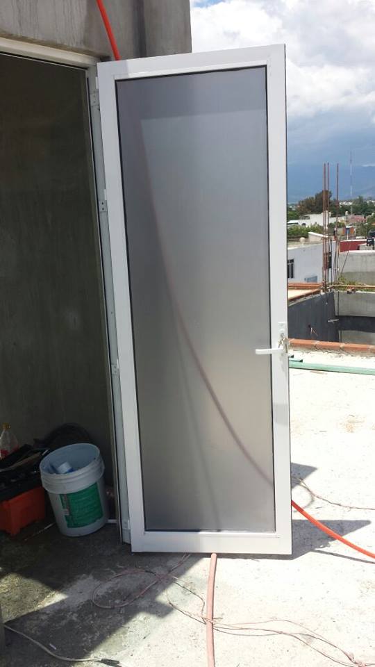 Puerta tono blanco serie 1750 linea panorama, cristal claro con pelicula esmerilada.