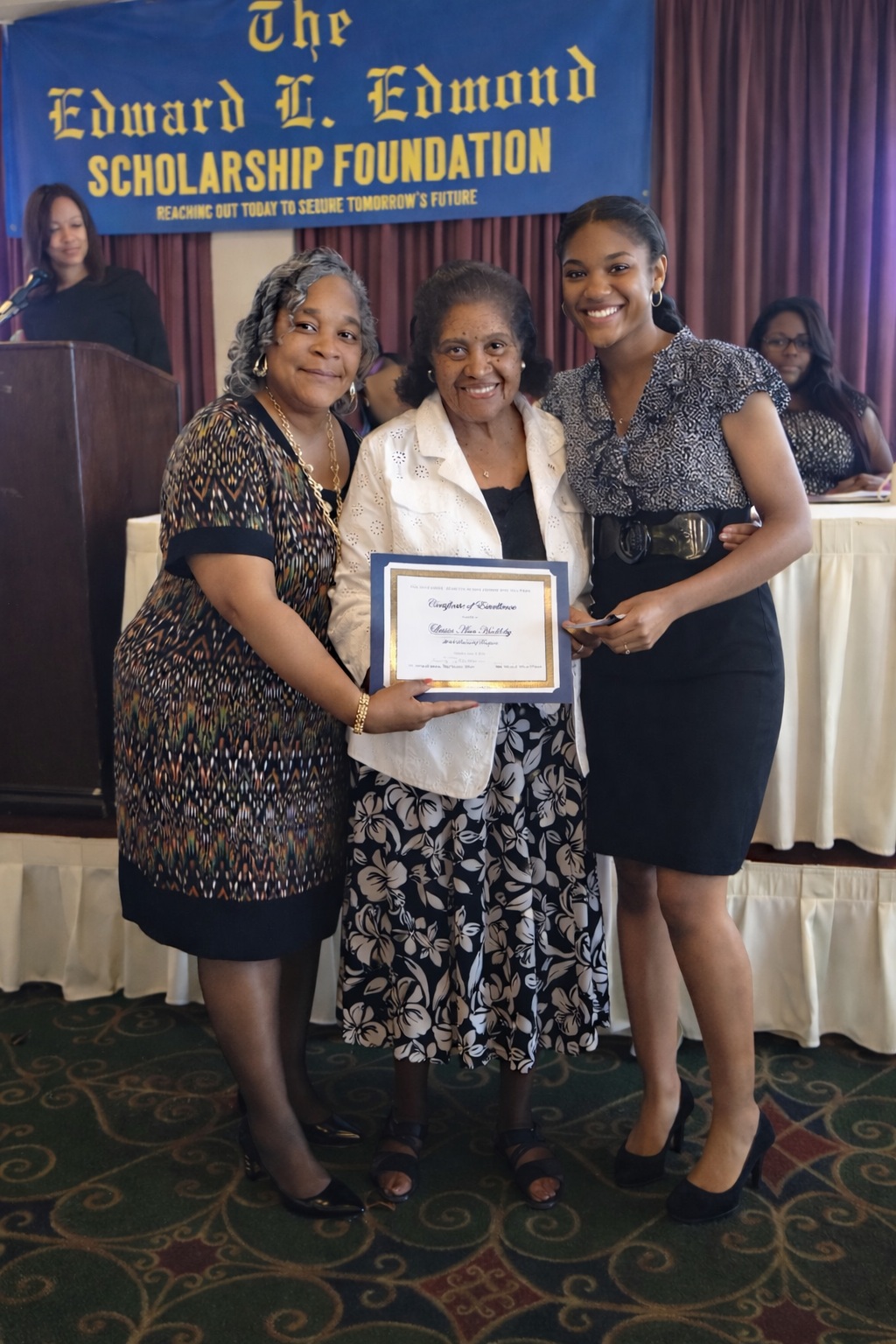 Confident woman in gray blazer smiling in modern office environment.