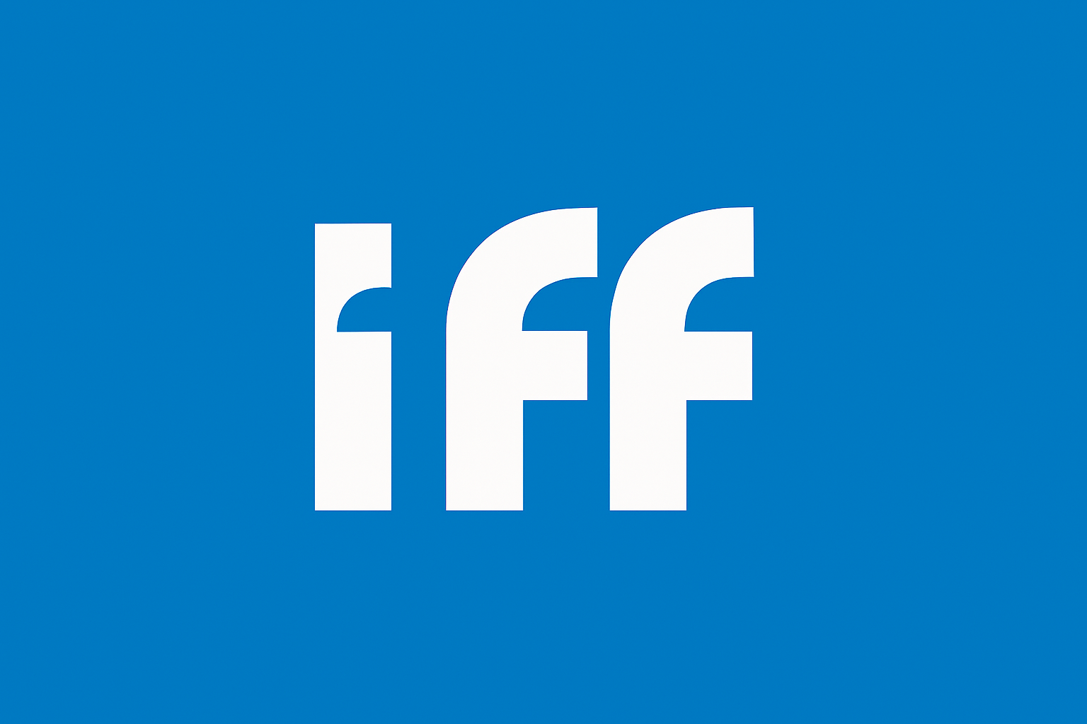 Vista de un moderno complejo urbano con altos edificios de cristal, grúas de construcción y árboles alineados a lo largo de un bulevar.