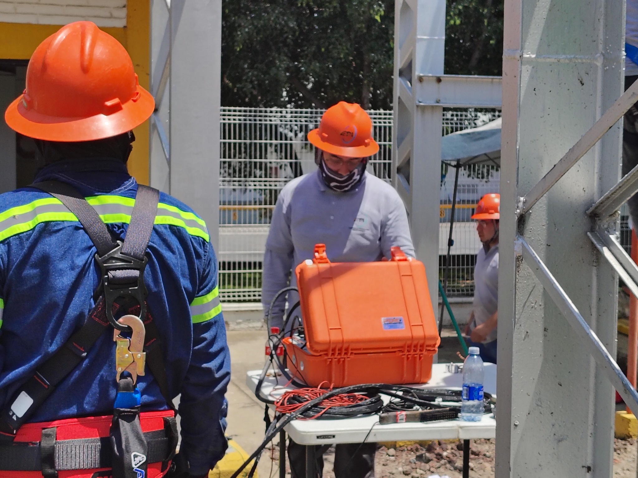 Trabajador en planta de fabricación con equipo de protección y tablet, fondo de laboratorio.