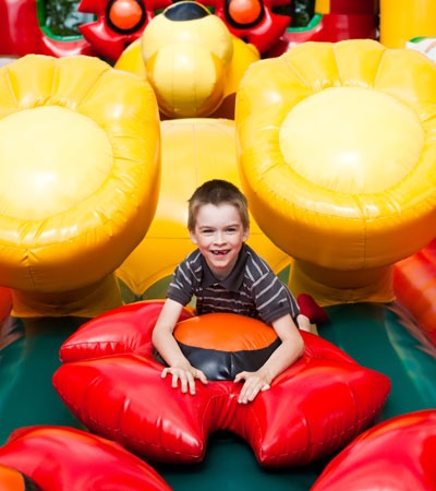 Boy In Inflatable Playground