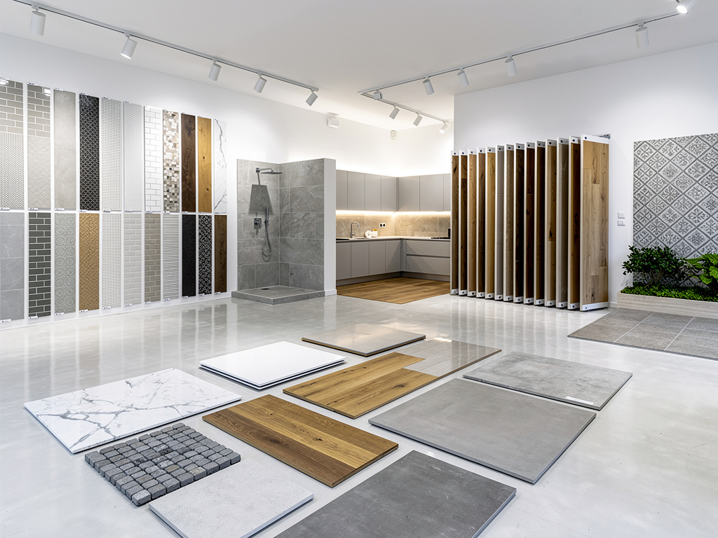 Sala de exposición de azulejos, suelos de madera, cerámica y baño moderno con muestras de revestimientos