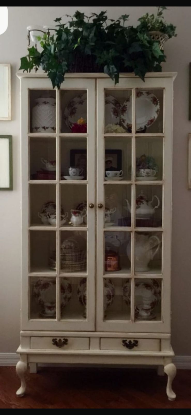 Modern bedroom with large window, neutral tones, abstract wall art, cozy bed, and indoor plant.