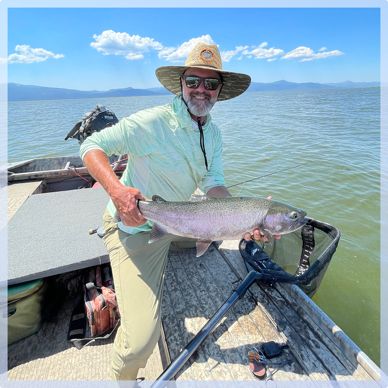 Man holding a large fish on a boat.