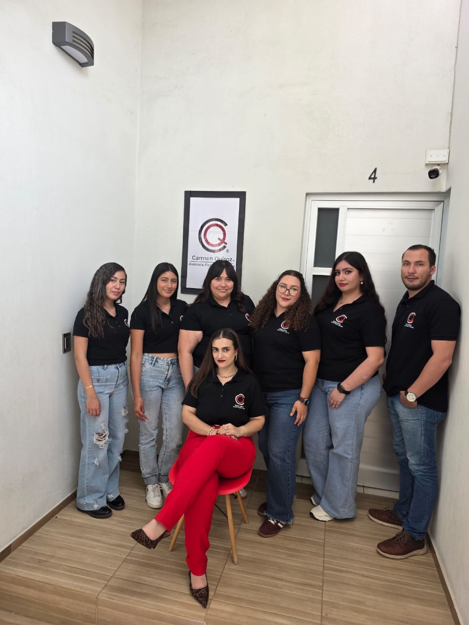 Equipo ejecutivo trabajando en oficina moderna con monitores, ventanales y vista urbana