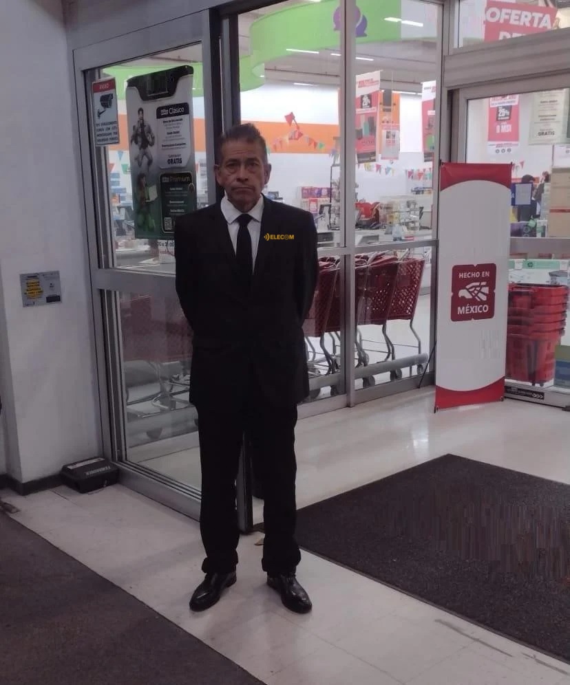 Moderno showroom de autos con un automóvil blanco al centro y personas caminando en un espacio amplio y brillante.