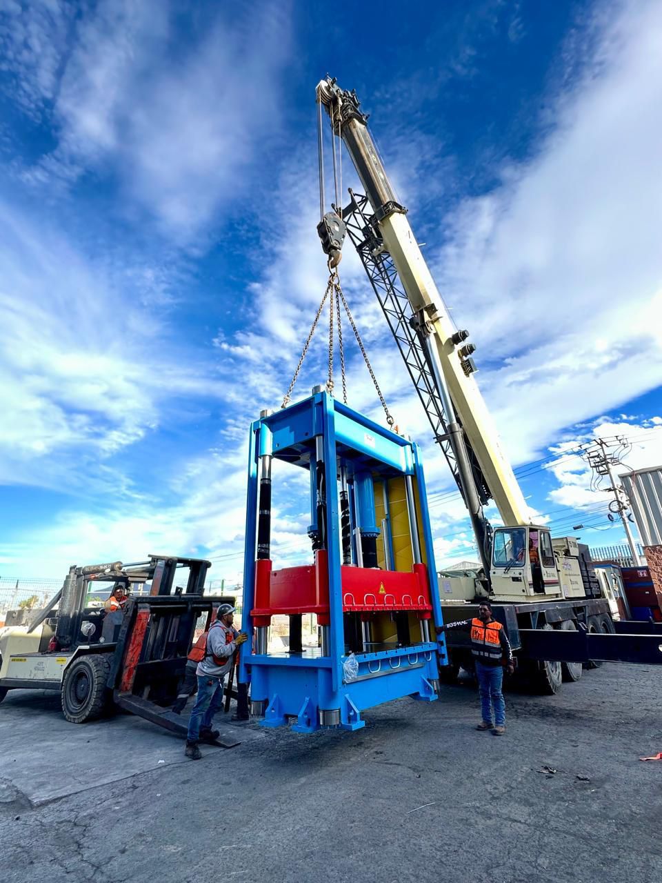 Carretilla elevadora amarilla en un almacén industrial con estanterías y cajas de fondo.